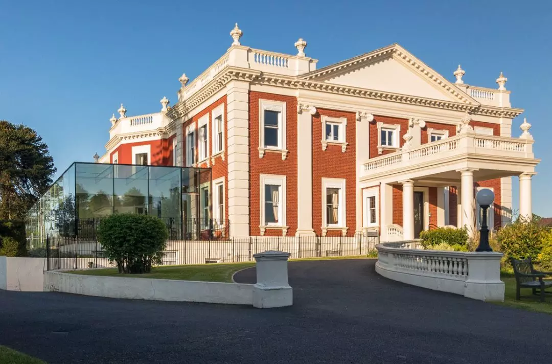 A photo of Sunbury Court in the sunshine. Sunbury court is an 18th-century mansion with a modern glass extension.