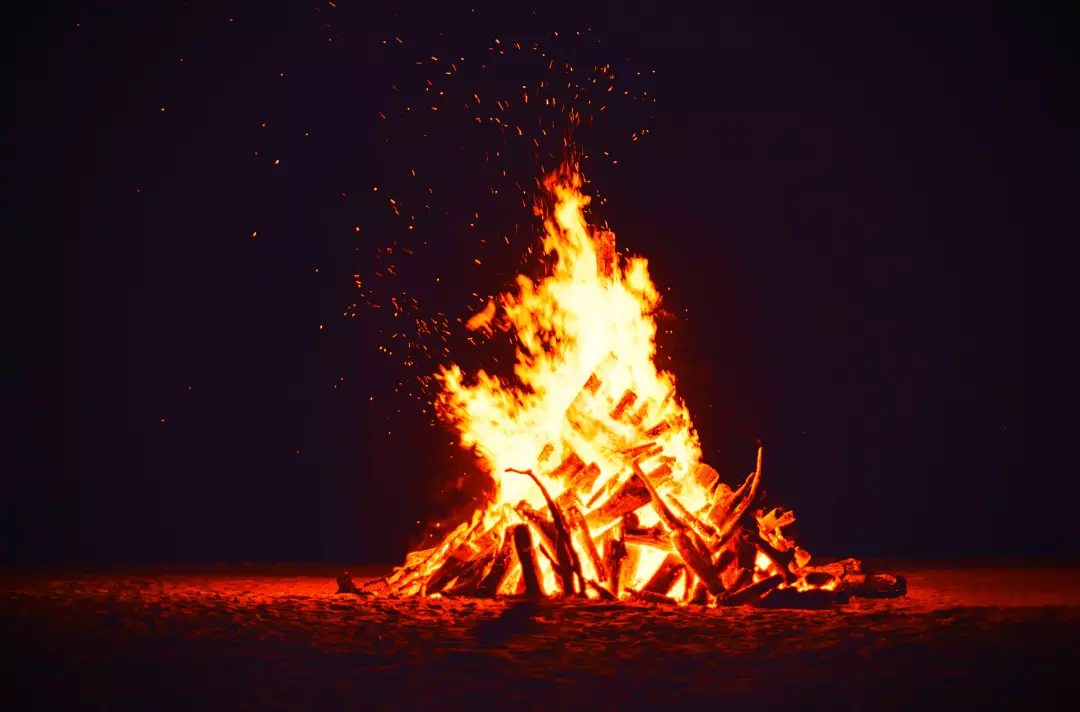 Photo shows a bonfire at night.