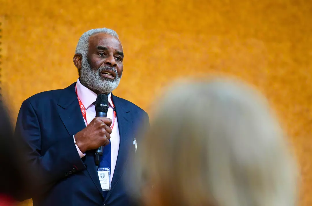 Image shows Neville Lawrence speaking from a platform.