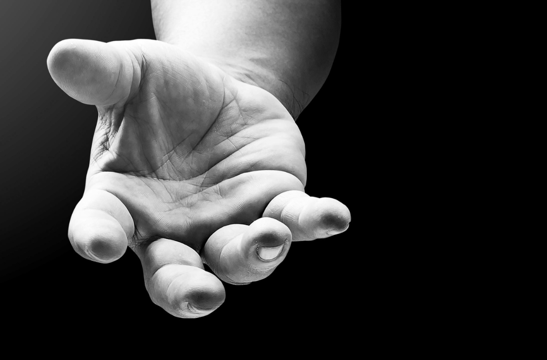 A black and white image shows a hand reaching out.