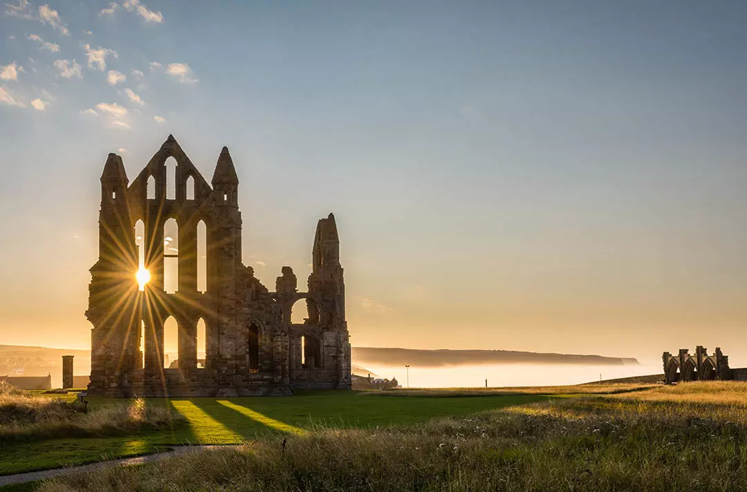 Whitby Abbey at sunrise surrounded by mist