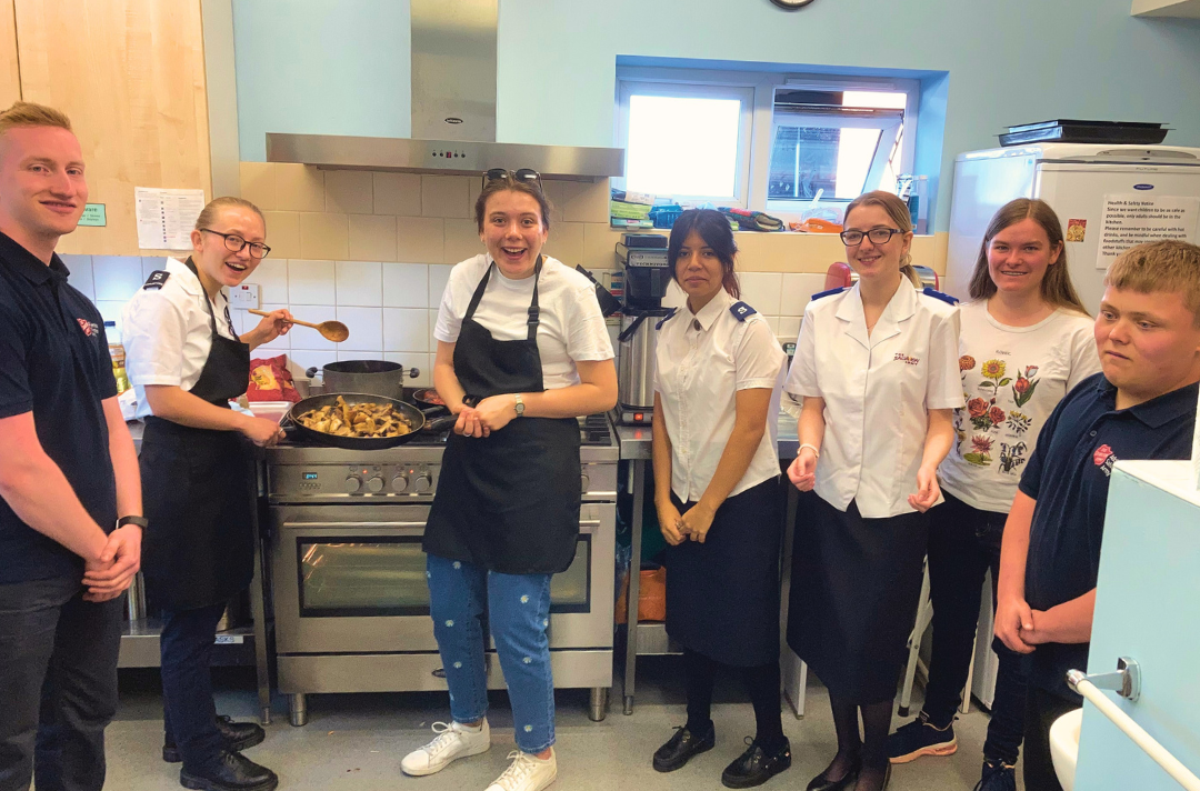 Photo shows people connected to the Addlestone Corps gap year cooking.