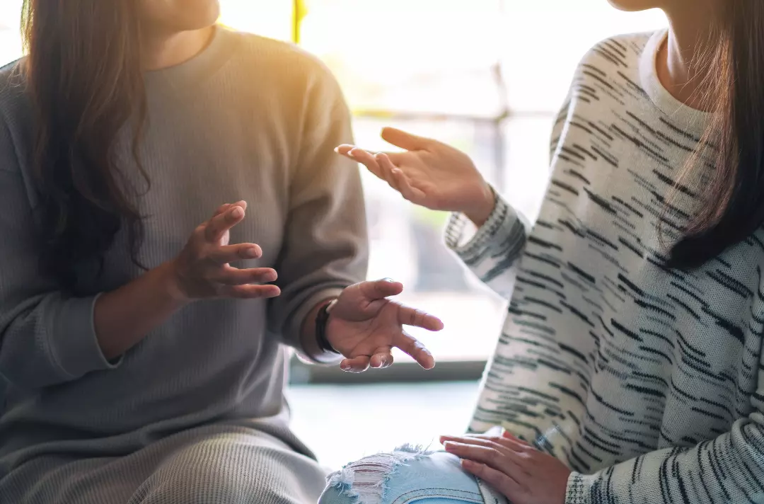 Photo shows two people talking.