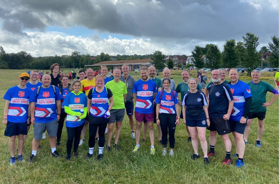 A group photo of people wearing Salvation Army branded running clothes in a park