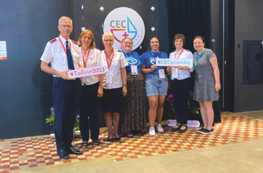 Photo shows the delegates who attended the 2023 Conference of European Churches posing with signs that read #Tallinn2023 and #CECassembly.
