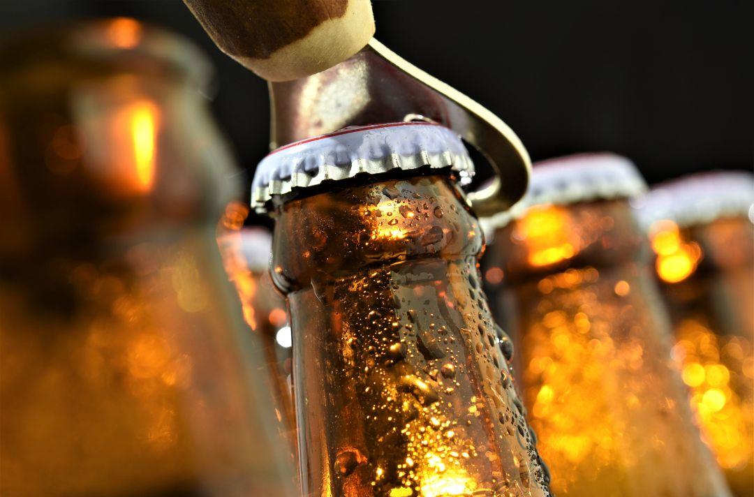 A photo of a brown bottle being opened