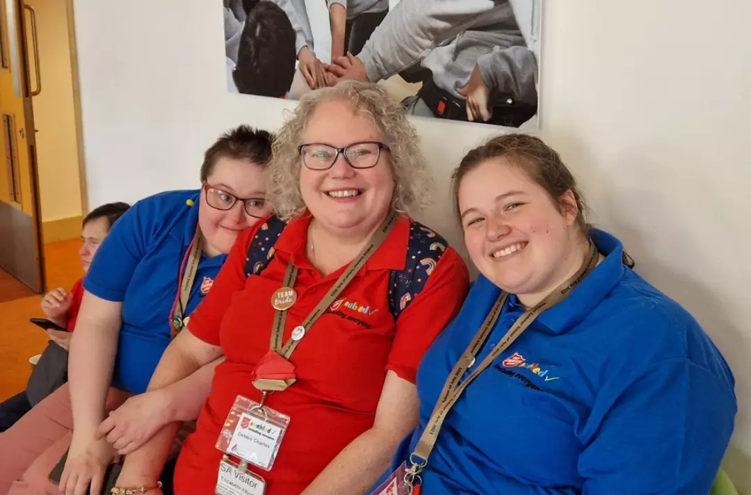 A photo shows three people smiling at the camera as they relax before the final celebration.