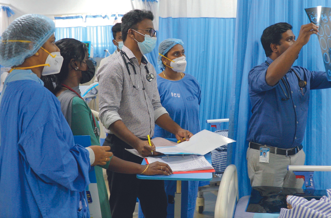 Photo shows people in medical scrubs in a hospital ward.