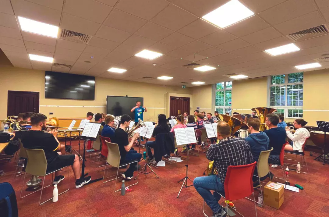 A photo shows young people playing brass instruments during a practice at Territorial Music School 2023.