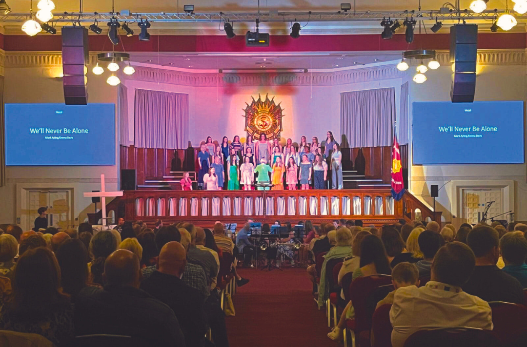 Photo shows a group of young people performing on the William Booth College platform during Territorial Music School 2023.