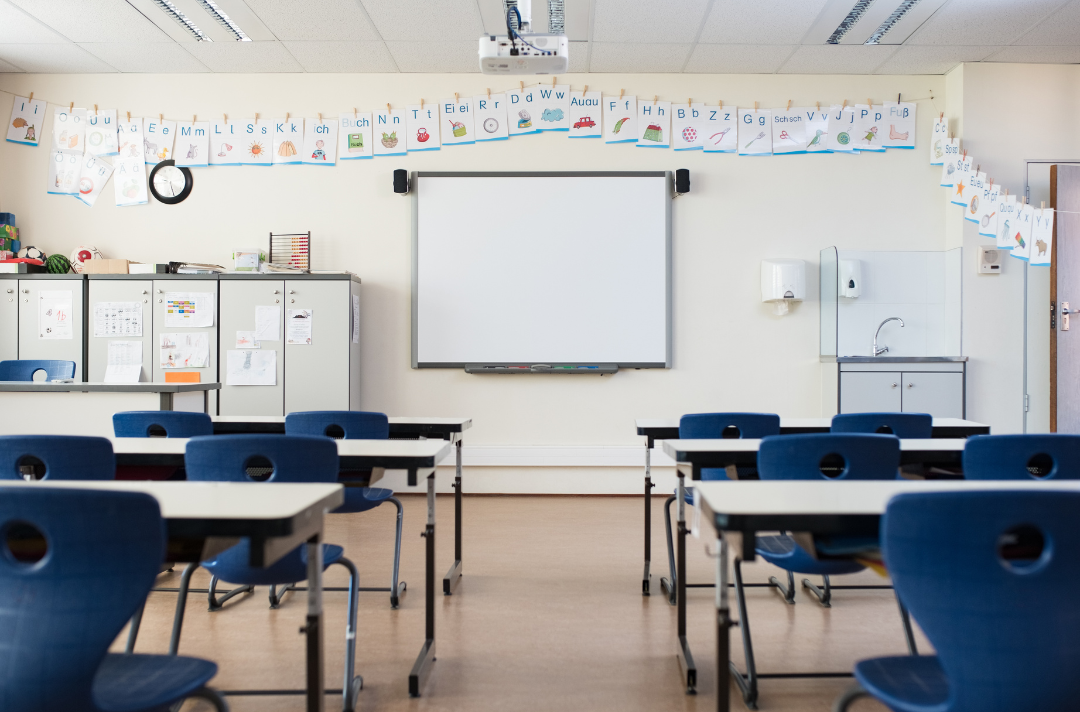A photo shows an empty classroom ready to receive students.
