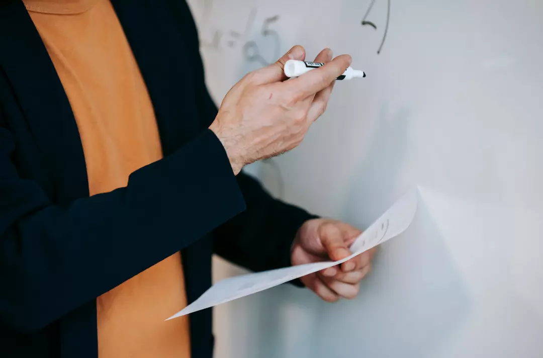 A photo shows a teacher at a whiteboard.