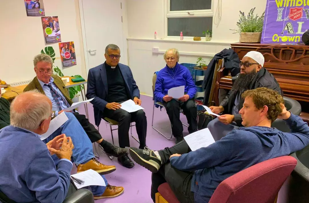 A photo shows a group of people from different backgrounds sat in a circle.