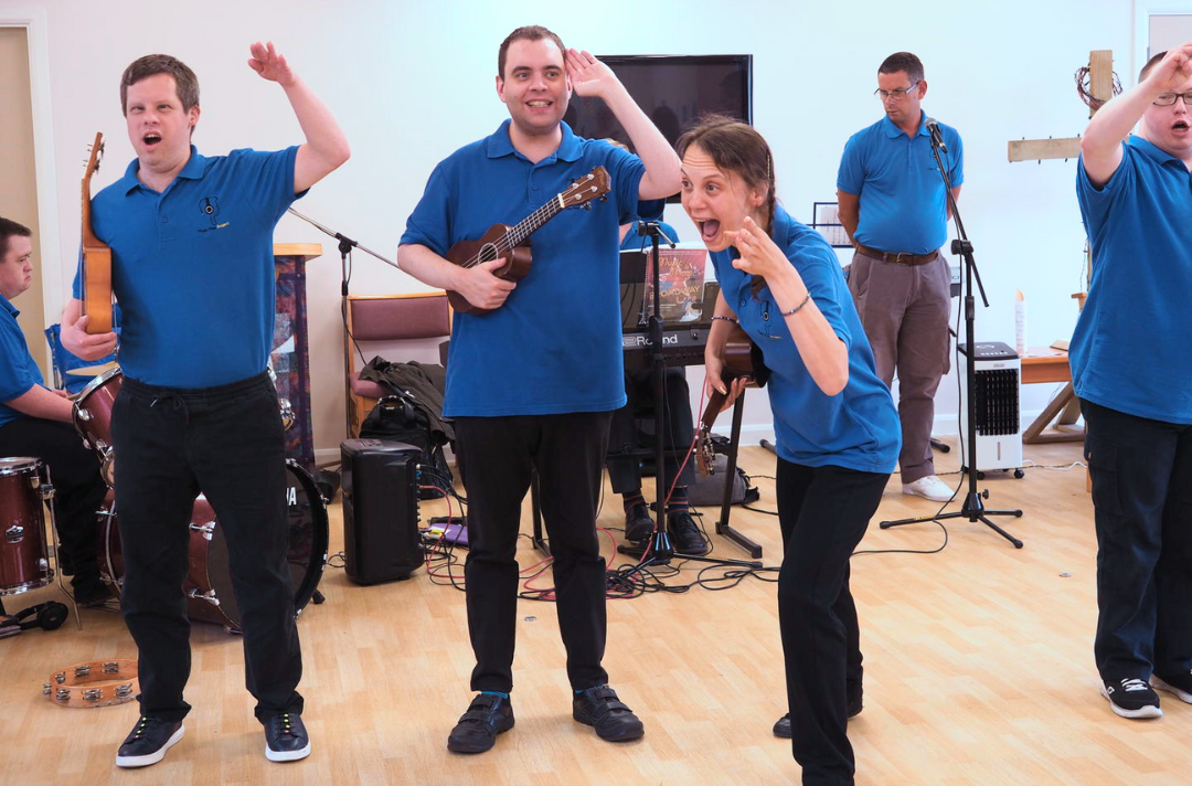 A photo shows three people with ukuleles performing as part of the Music Man Project.