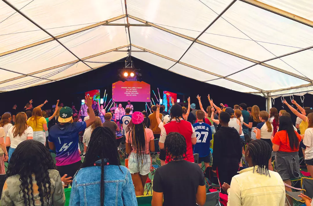 A photo shows members of the London and South East Summer School engaged in worship.