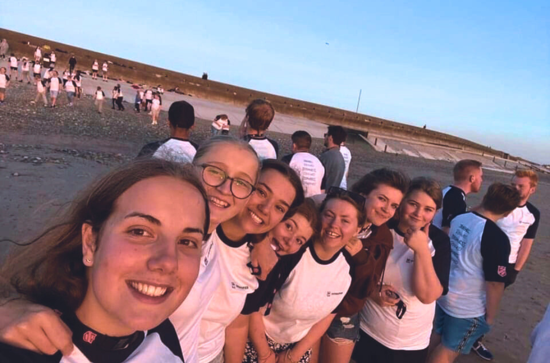 A photo shows a selfie of a group of members from the North West and Isle of Man Summer Camp.