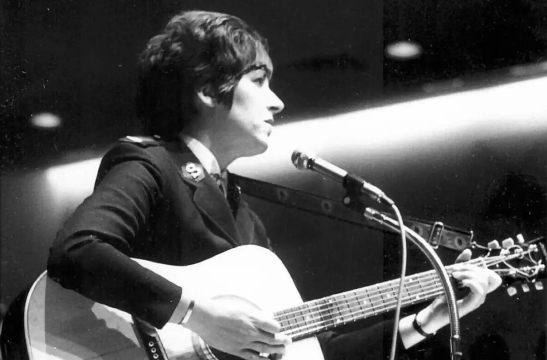 A black and white photo shows Major Joy Webb playing guitar.
