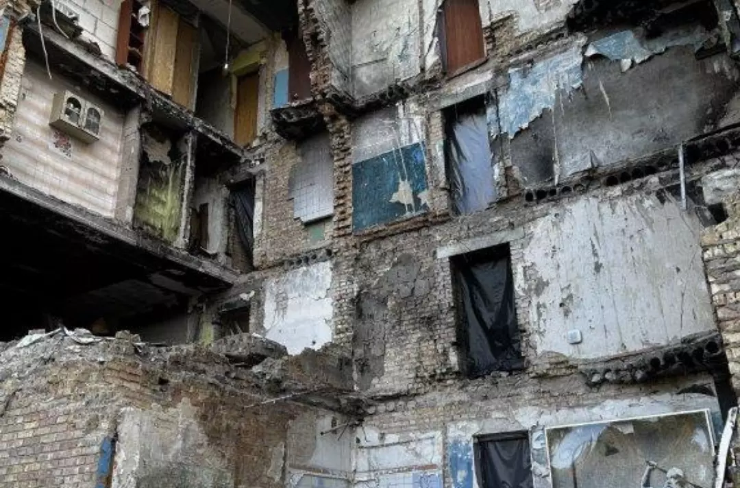 A photo shows a bombed-out flat. The only remaining furniture appears to be a single kitchen cupboard.