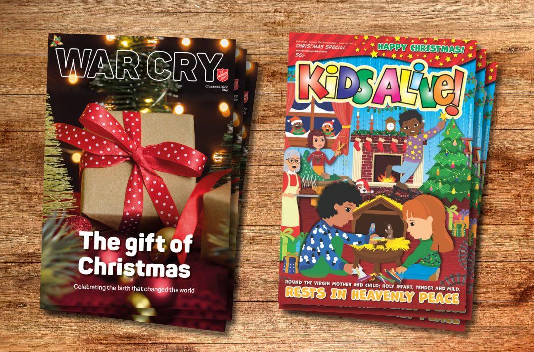 A pile of Christmas issues of the War Cry on a wooden table next to a pile of Christmas issues of Kids Alive!