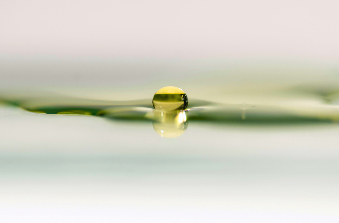 A photo shows a drop of water delicately balanced on a rippling surface.