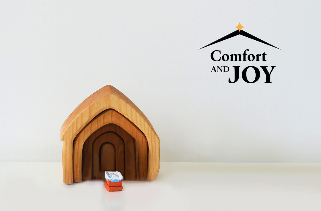 A photo shows a wooden manger scene with only a baby Jesus figure present. Text reads: Comfort and joy.