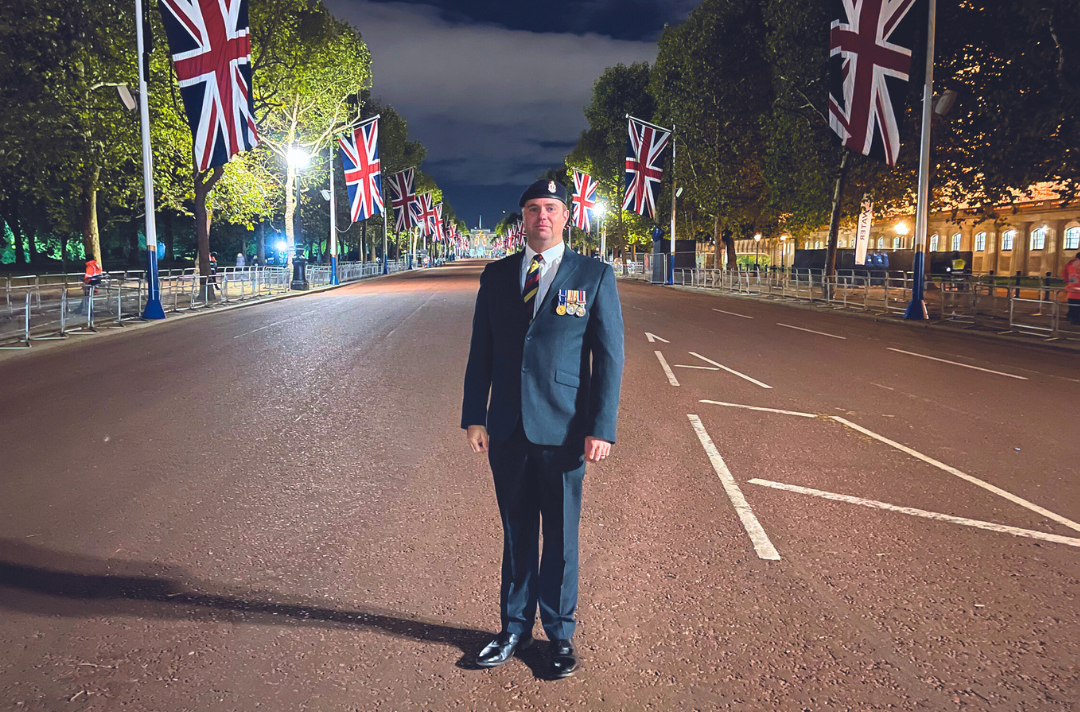A photo shows Kevin Russell wearing his medals and standing on The Mall, London, at night.