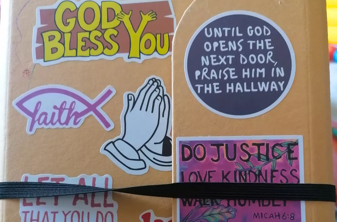 A photo shows the cover of a Welling Corps prayer journal.