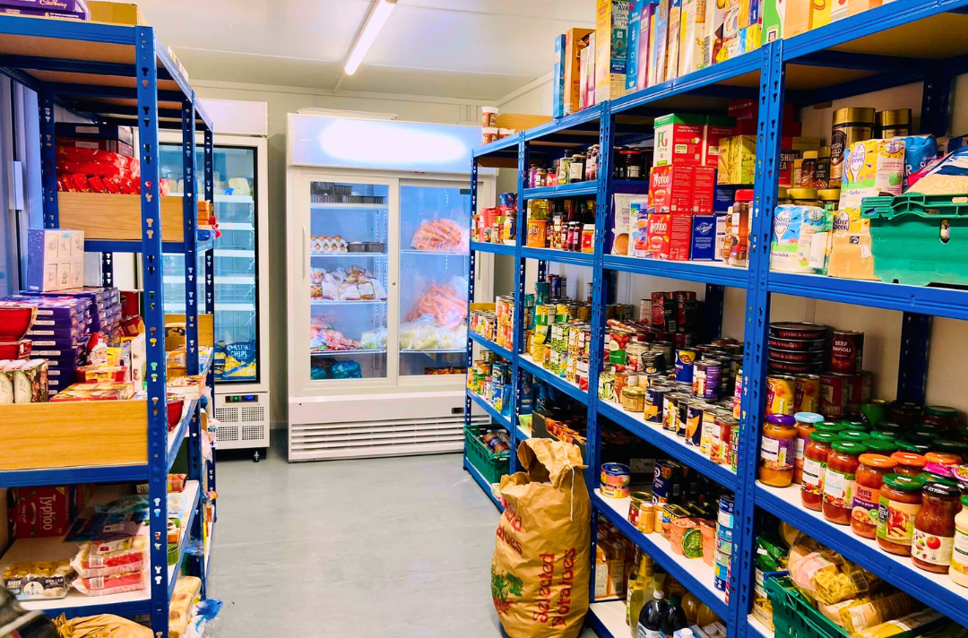 A photo shows a social supermarket stocked with food.