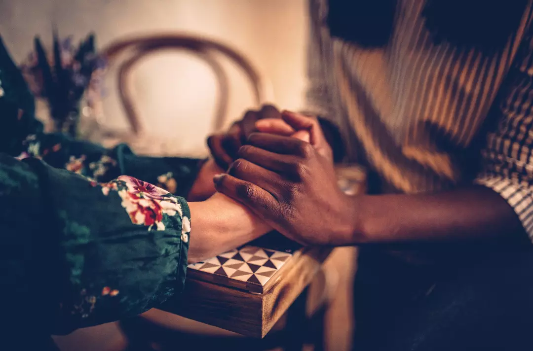 A photo shows two people holding hands.