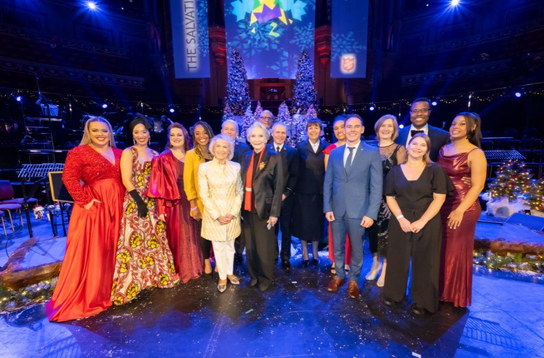 The performers of Celebrating Christmas with The Salvation Army 2023 gather for a group photo on stage of the Royal Albert Hall after the concert