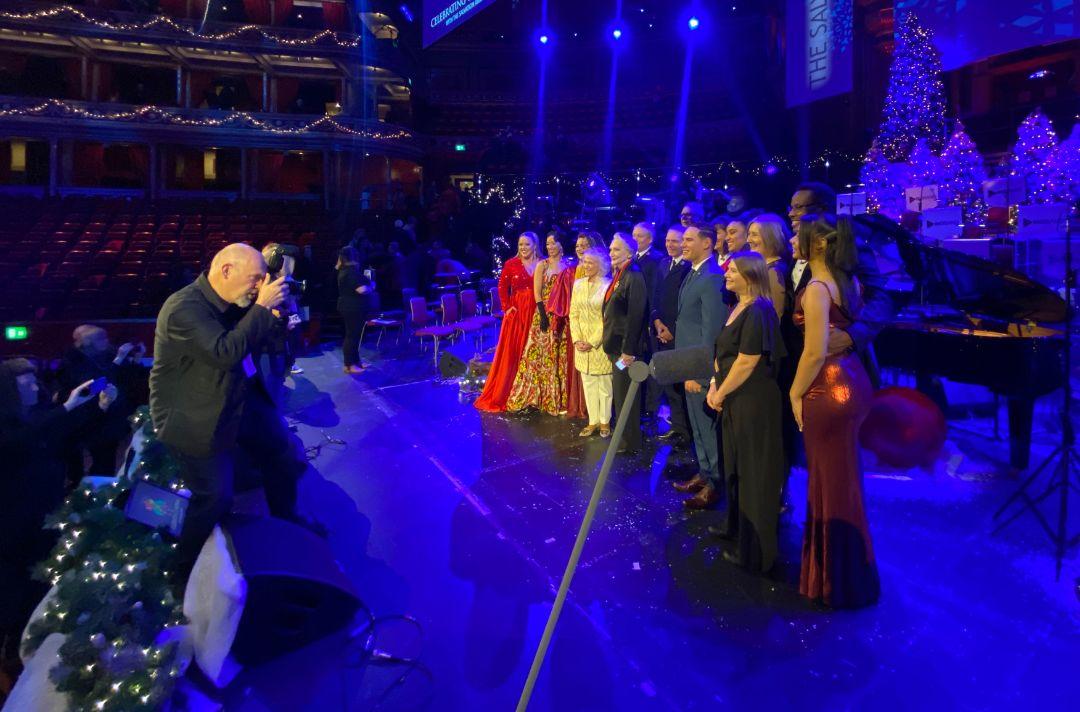 A photo of the performers posing for a group photo on stage of the Royal Albert Hall