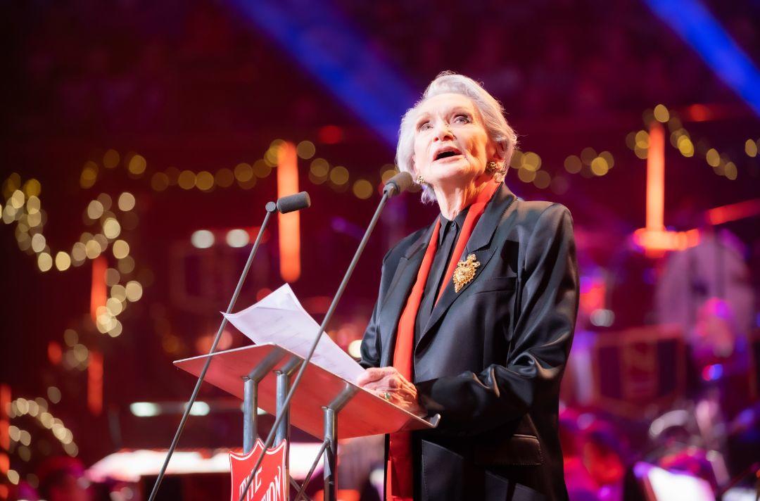 A photo of Siân Phillips reading the Bible on stage of the Royal Albert Hall