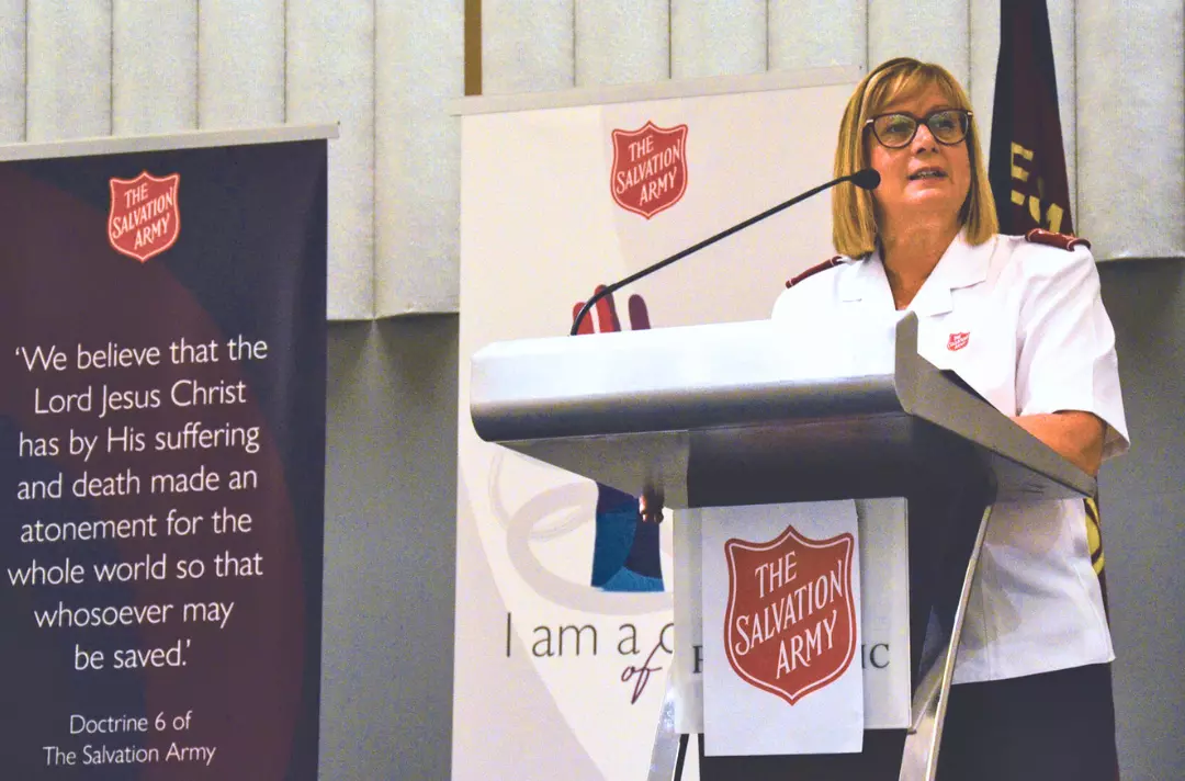 A photo of Julie Forrest speaking at a podium.