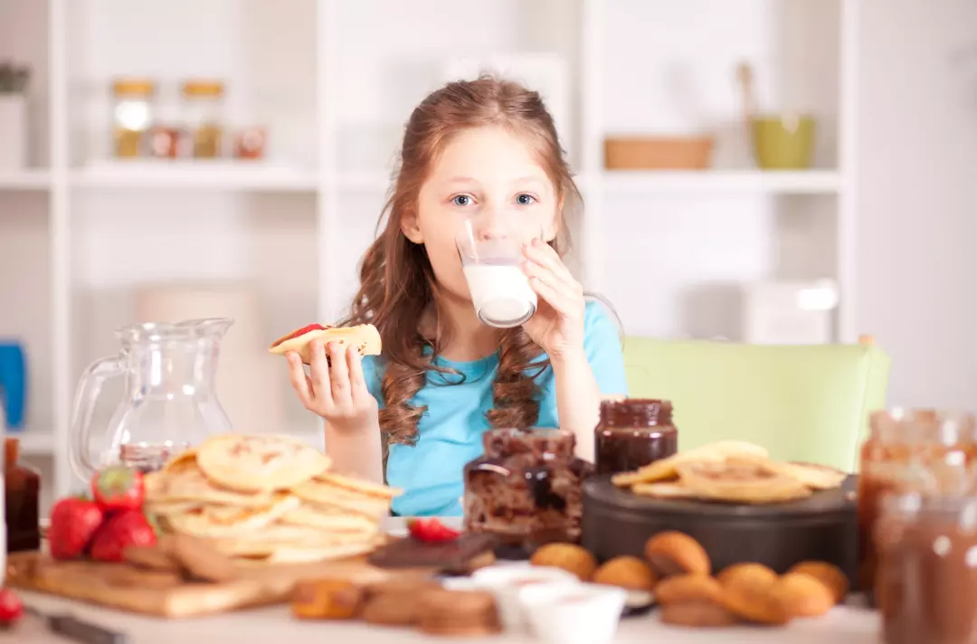 A photo of a child eating pancakes