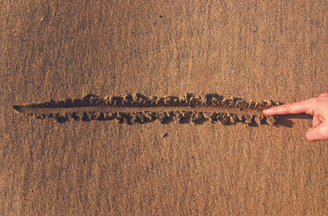 A photo of Jesus drawing a line in the sand