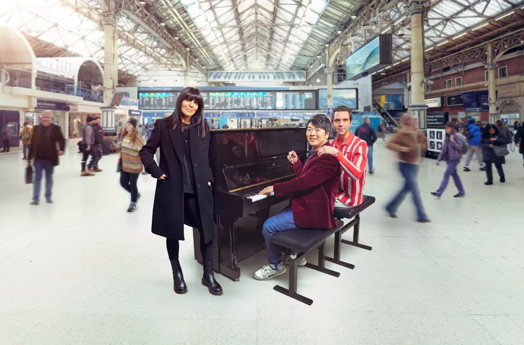 A photo shows people gathered around a piano in a busy train station.