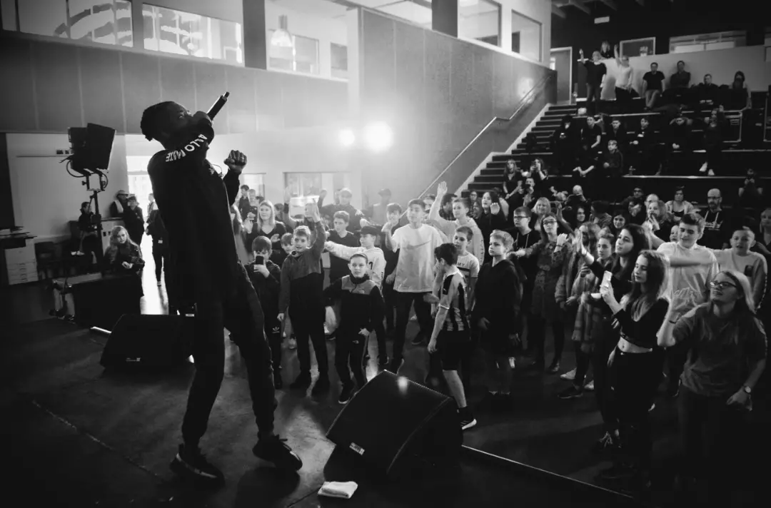 A black and white photo shows a young people attended a rap concert.