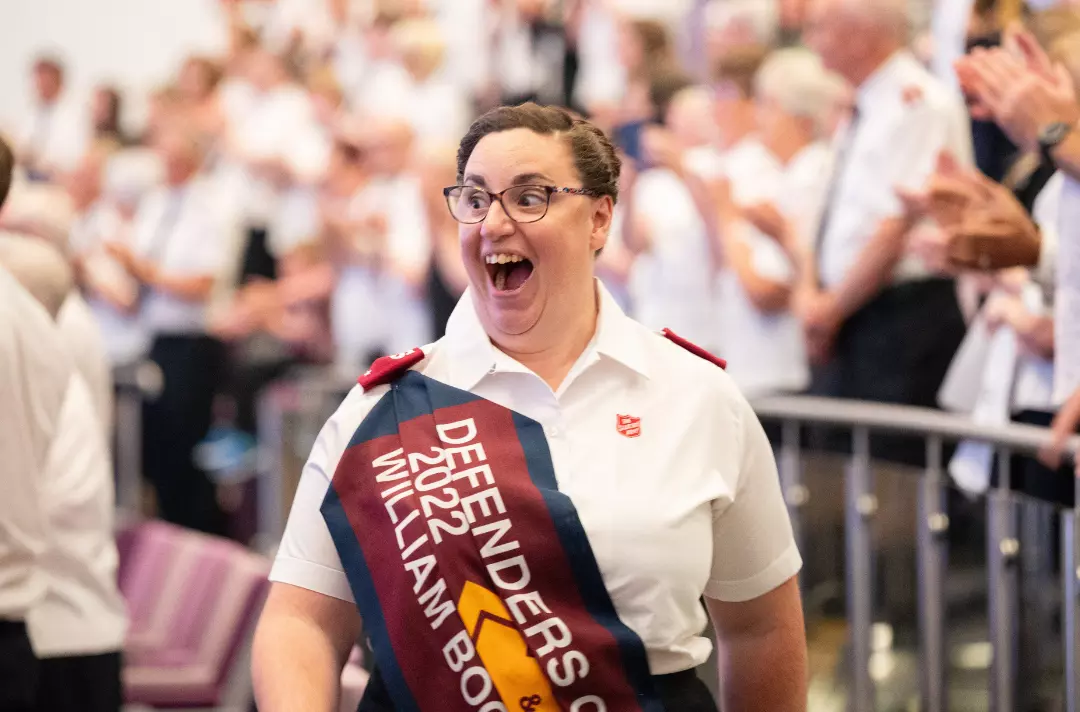 A photo shows a freshly-commissioned lieutenant marching into the meeting hall.