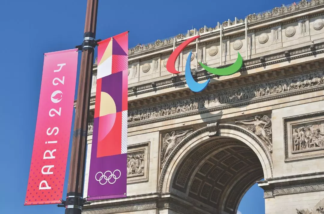 A photo of a Paris 2024 banner in front of the Arc de Triomphe