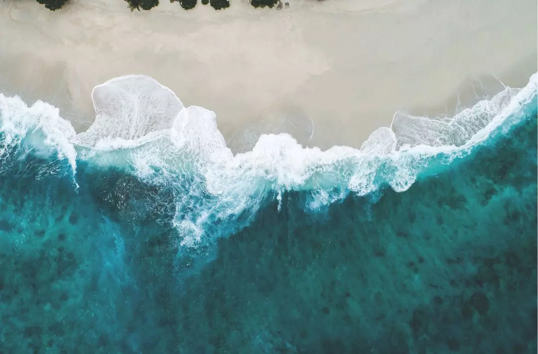 Blue waves splashing on golden yellow beach