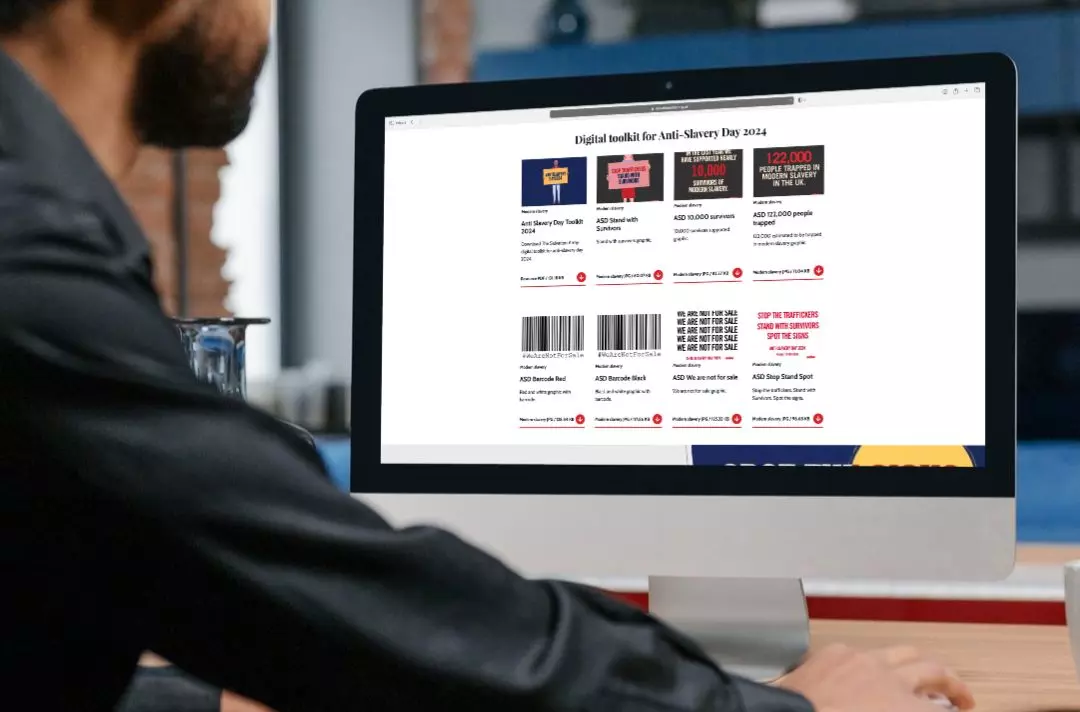 A photo of someone looking at the Anti-Slavery Day digital toolkit on salvationarmy.org.uk - you can see lots of resources available to download featuring the #WeAreNotForSale temporary barcode tattoo design