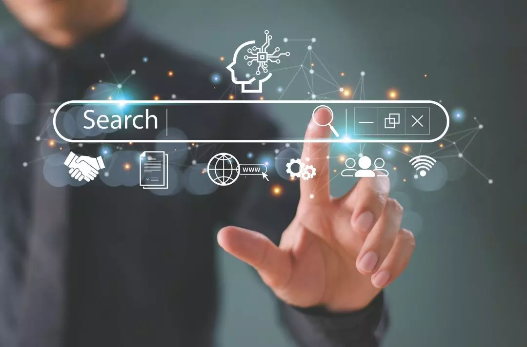 A photo of a hand tapping a search bar on a screen