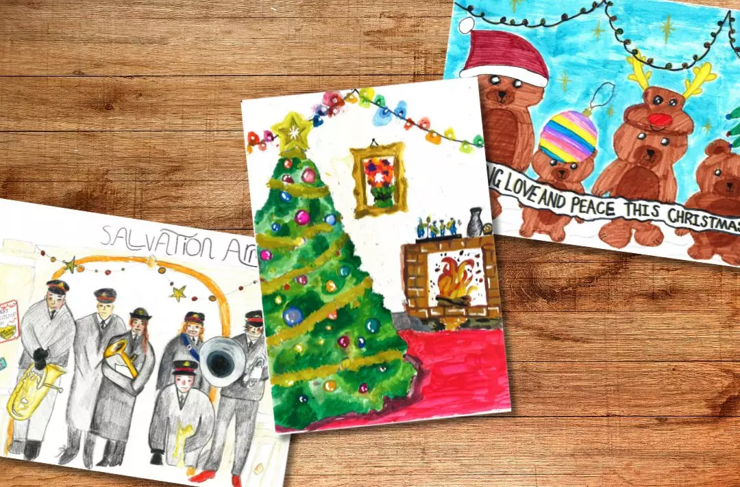A graphic shows three Christmas card designs against a wooden background. The three cards depict: 1) A colour drawing of a uniformed Salvation Army band posing for the image. 2) A painting of a verdant decorated Christmas tree in a room with a fireplace. 3) A colour drawing of a family of teddy bears wearing Christmas-themed accessories.