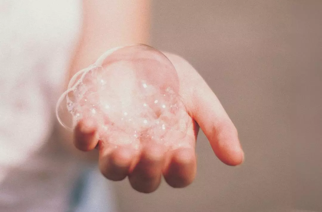An open hand with soap bubbles