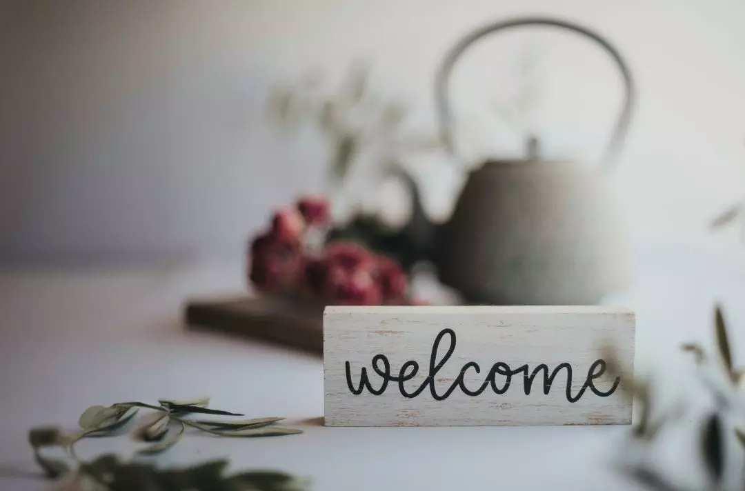A welcome sign and tea pot