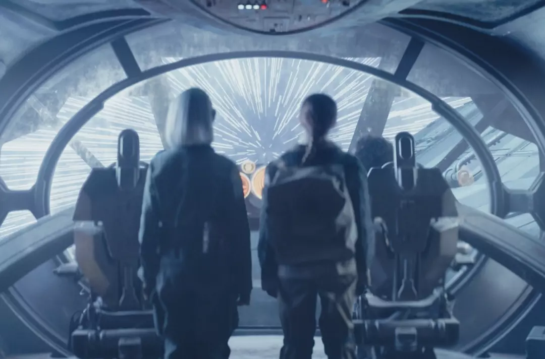 A scene from Star Wars: Skeleton Crew shows people standing around the cockpit of a starship, looking out the window as it achieves lightspeed.