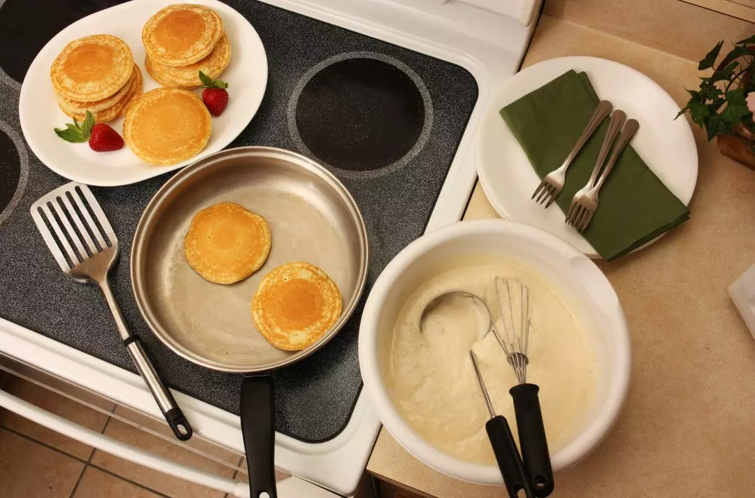 A photo of pancakes being cooked on a stove