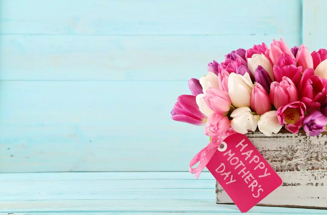A bunch of pink, white and purple tulips with a tag that reads 'Happy Mother's Day'