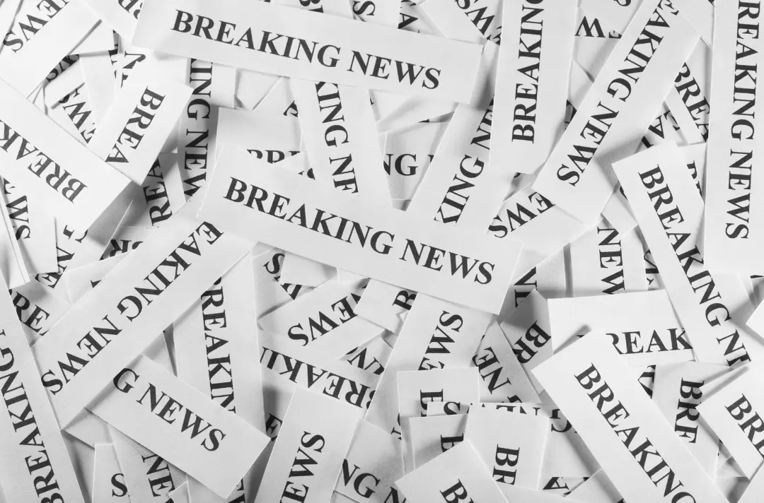 An image shows a pile of pieces of paper which all read: Breaking news.