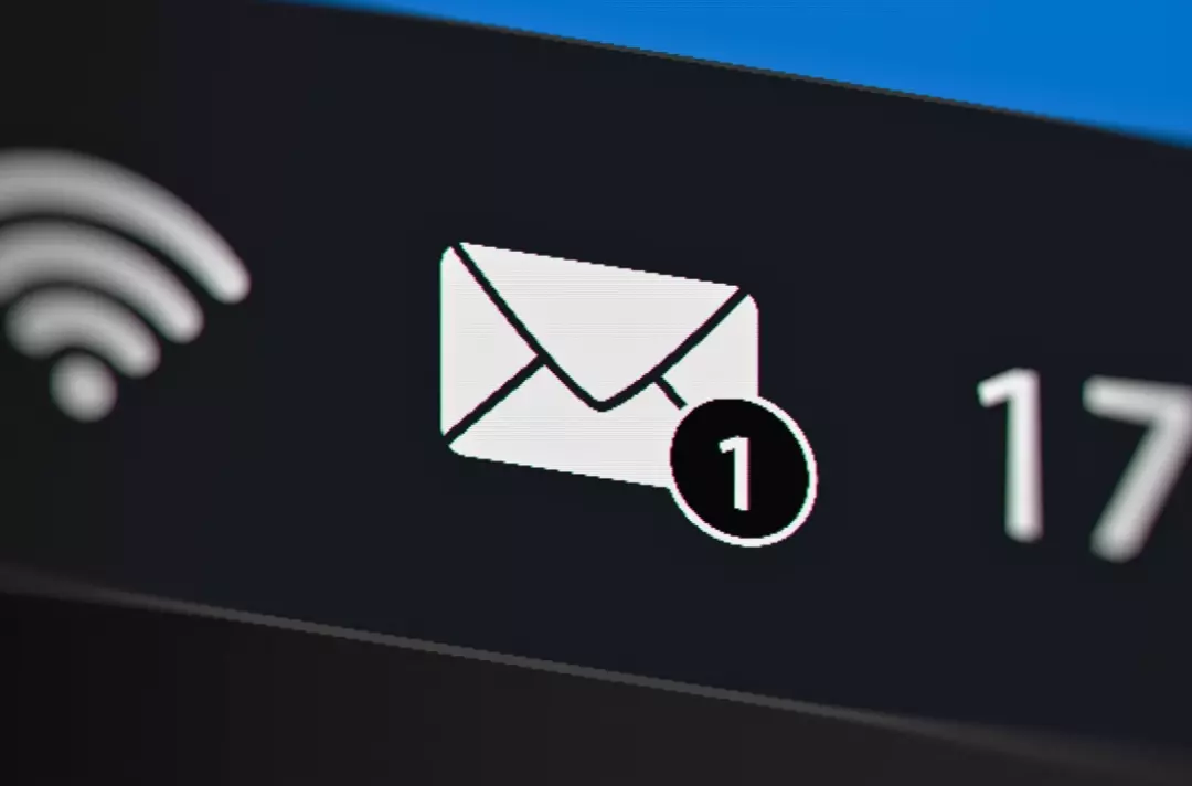 A photo shows a screen displaying an email app icon with a notification bubble.